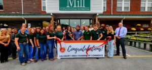 A group of individuals smiling with a congratulations banner.