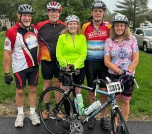 Rotarians Support the Christian Shelter A group of people standing with a bicycle.