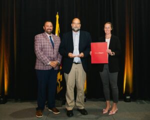 Justin Polizzi and Laura Soper present Tourism Person of the Year award to Bryan Ashby, Wicomico County Public Schools