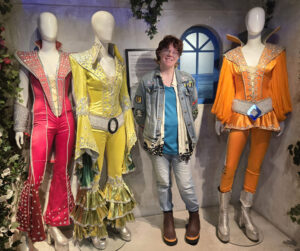 A person standing with fashion manikins