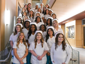 Nursing graduates smiling on the steps for a photo