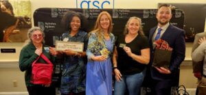 Five guests standing in front of Big Brother Big Sister sign