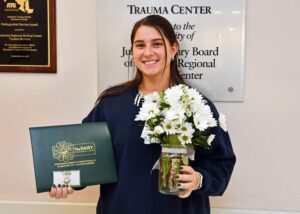 A girl holding an certificate with flowers
