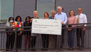 A group of people holding a large check