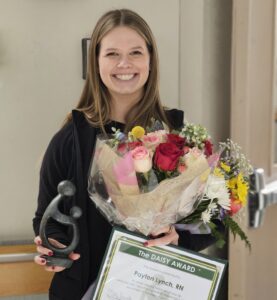 A girl smiling for her portrait with flowers