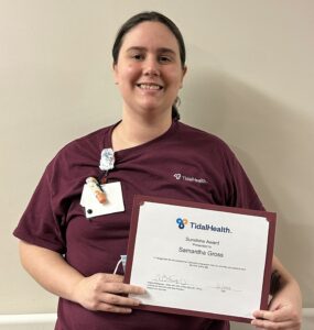A woman smiling a certificate